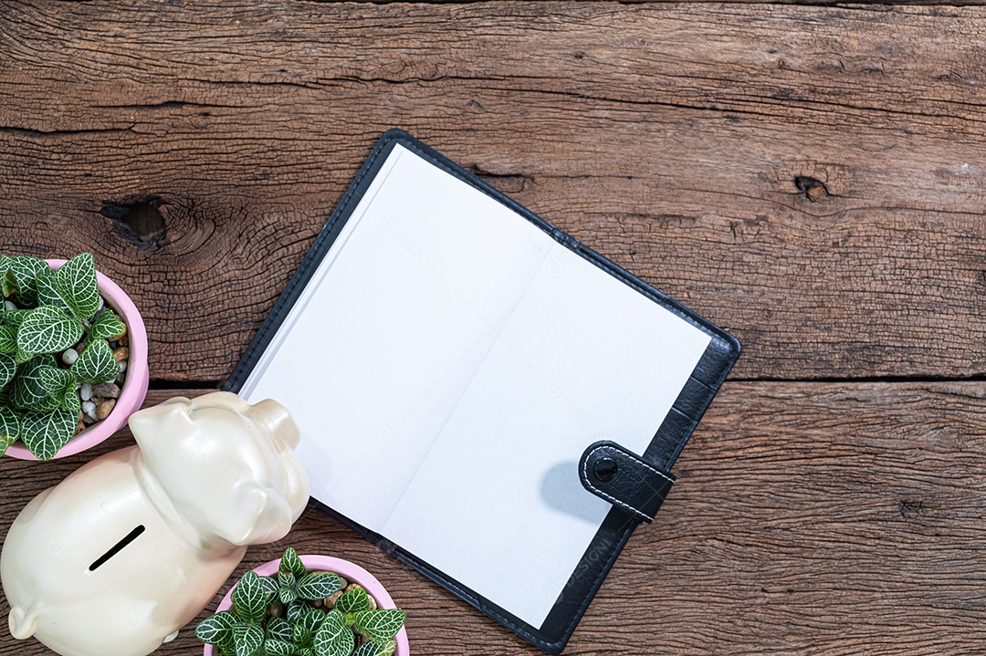 Caderno e cofrinho estão na mesa