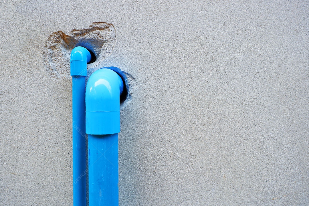 Canos de água de PVC são instalados atrás da casa.