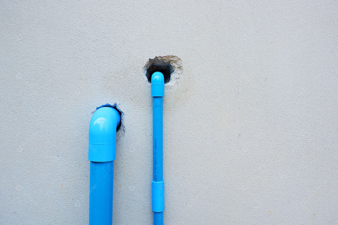 Canos de água de PVC são instalados atrás da casa.