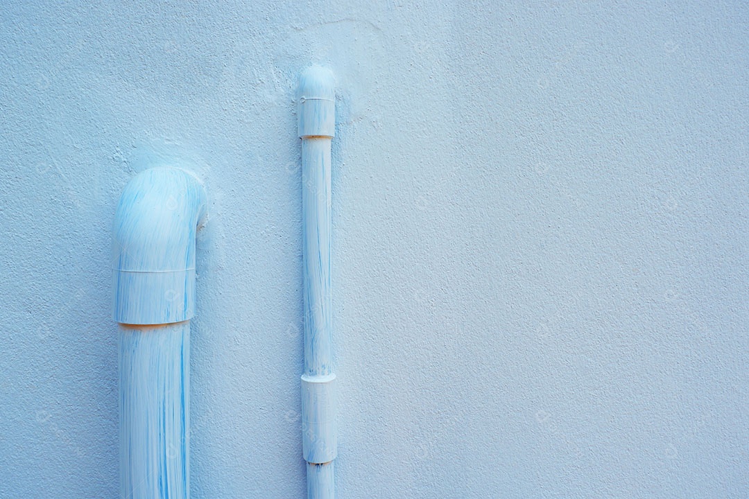 Canos de água de PVC são instalados atrás da casa.