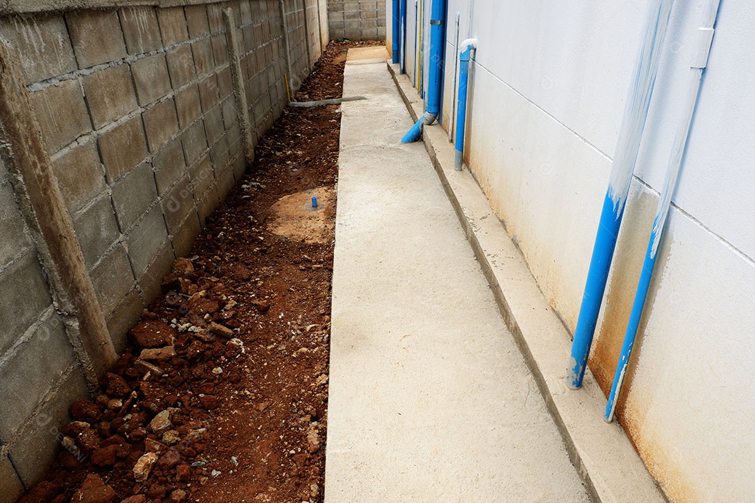 Canos de água de PVC são instalados atrás da casa.