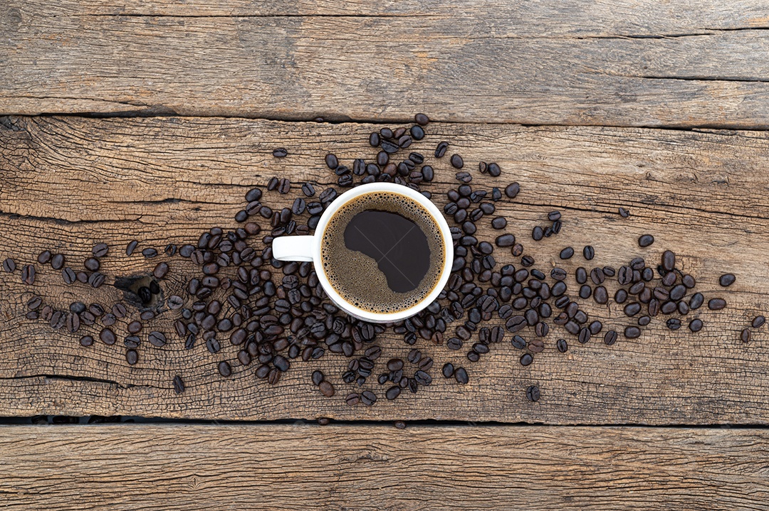 Canecas de café e grãos de café estão na mesa