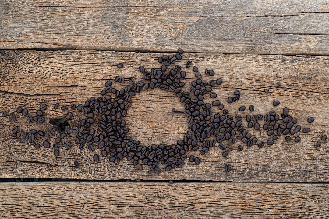 Grãos de café no chão de uma mesa de madeira