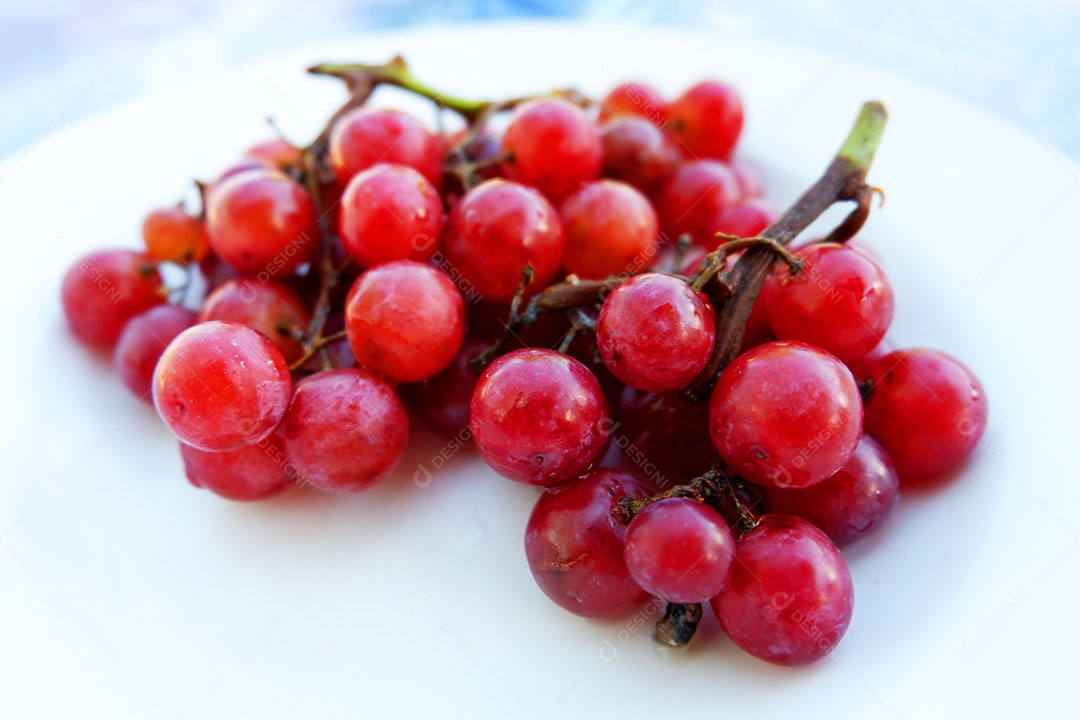 Uvas vermelha sobre prato branco