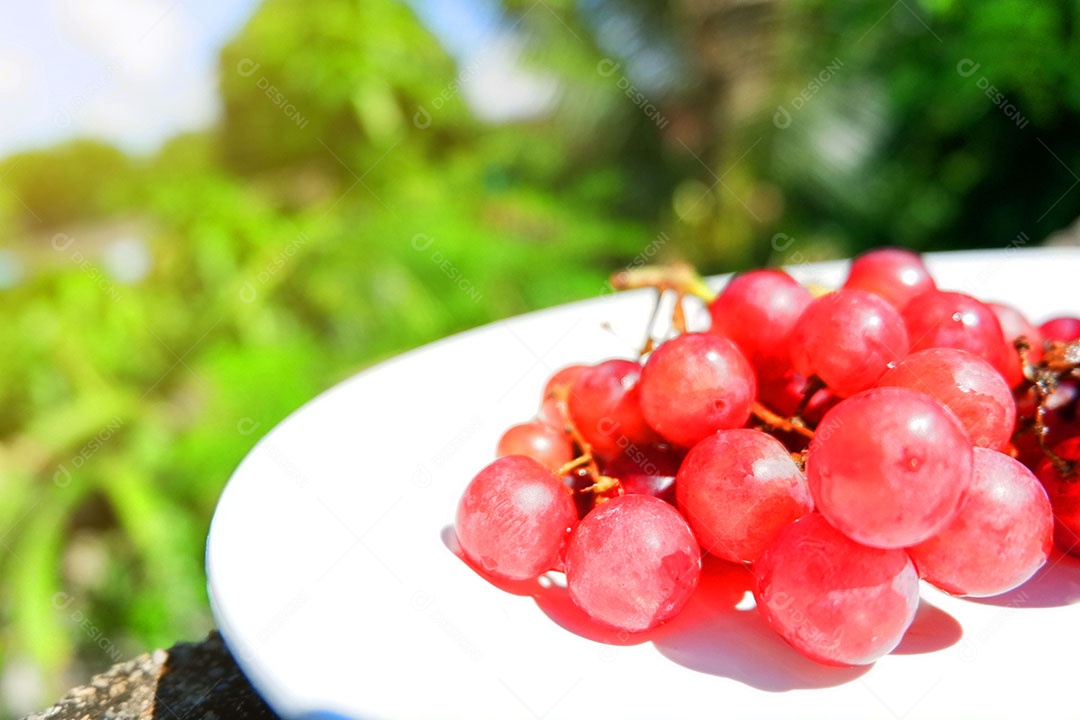 Uvas vermelha sobre prato branco
