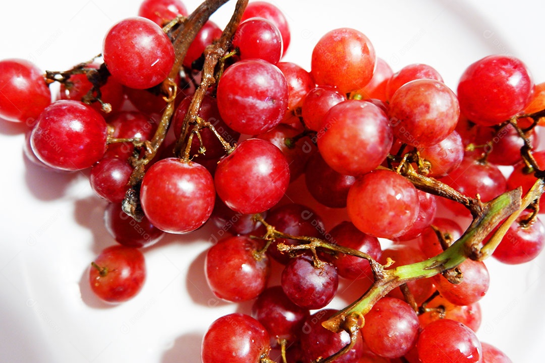 Uvas vermelha sobre prato branco