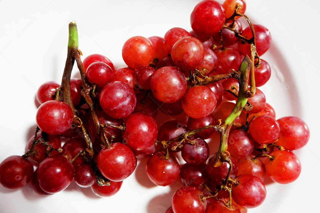 Uvas vermelha sobre prato branco