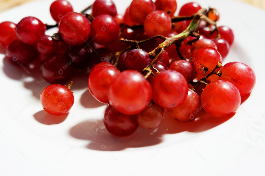 Uvas frutas sobre prato branco