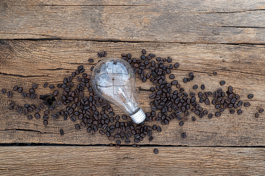 Lâmpadas e grãos de café Na mesa Vista superior