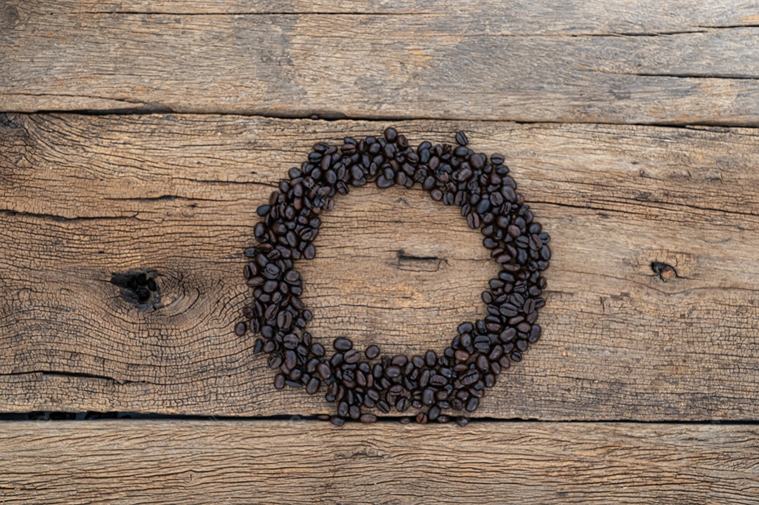 Grãos de café no chão de uma mesa de madeira
