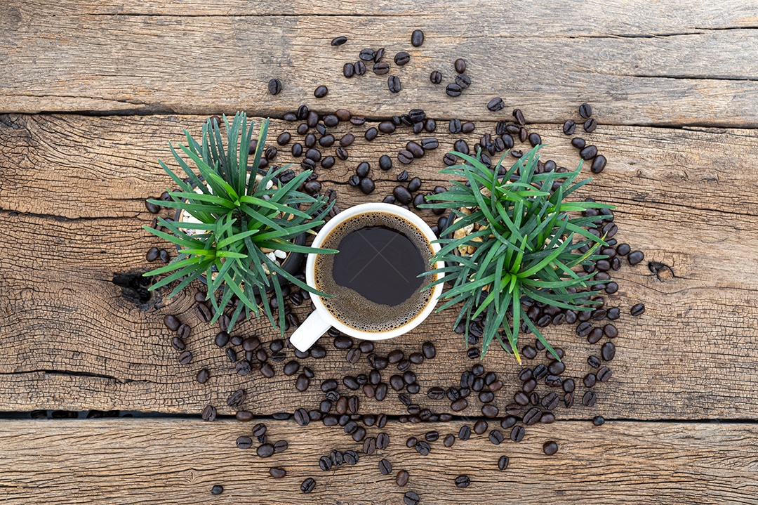 Canecas de café e grãos de café estão na mesa