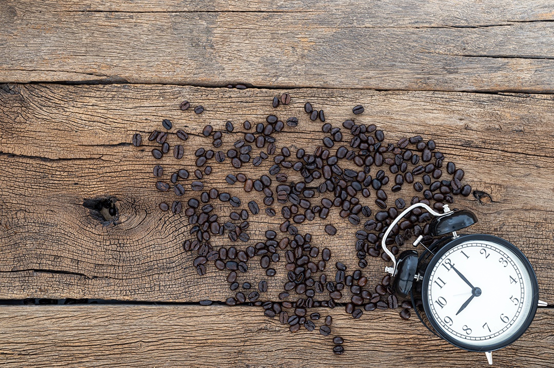 Relógio e grãos de café Na mesa Vista superior