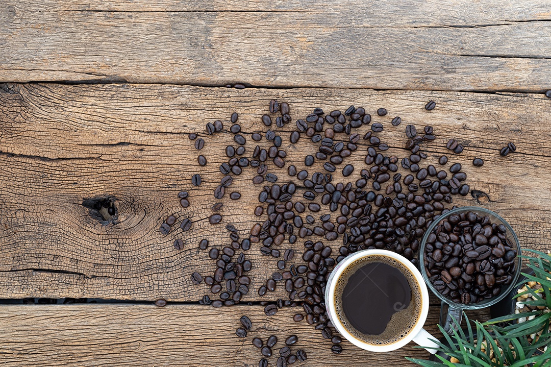 Canecas de café e grãos de café estão na mesa