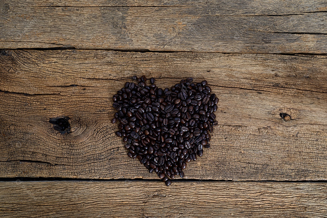 Grãos de café dispostos em forma de coração na mesa