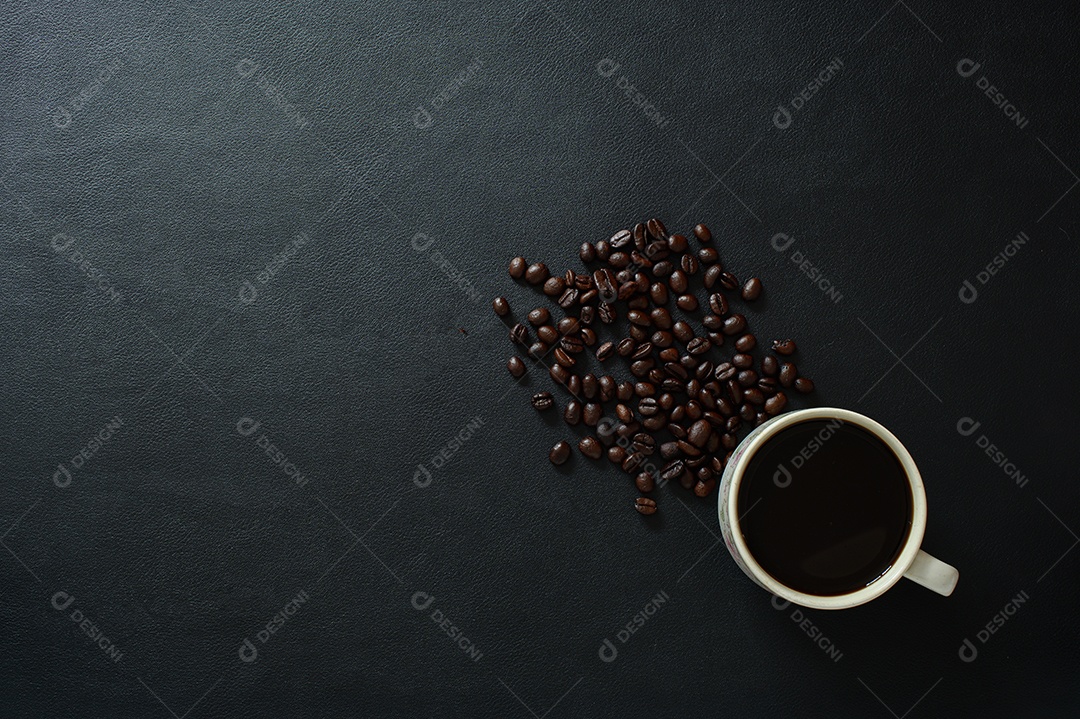 Canecas de café e grãos de café estão na mesa