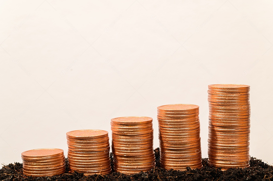 Gráfico crescente da pilha da moeda do dinheiro com fundo do bokeh da luz do sol