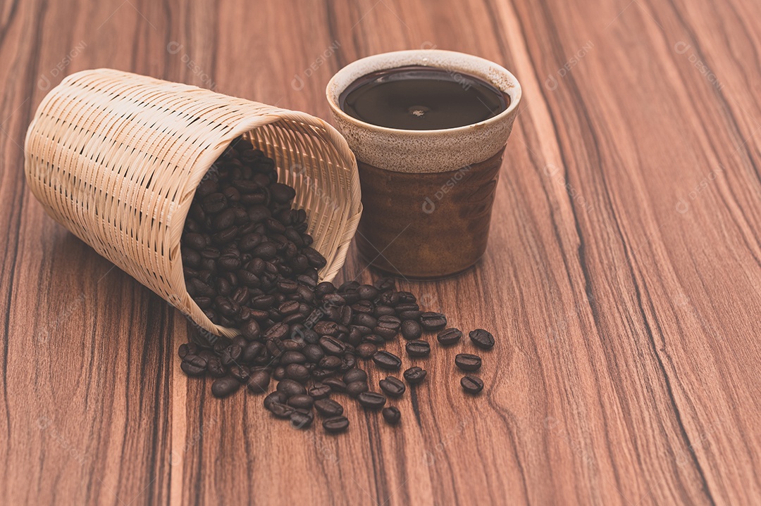 Conceito de beber café Grãos de café e xícaras de café estão sobre a mesa