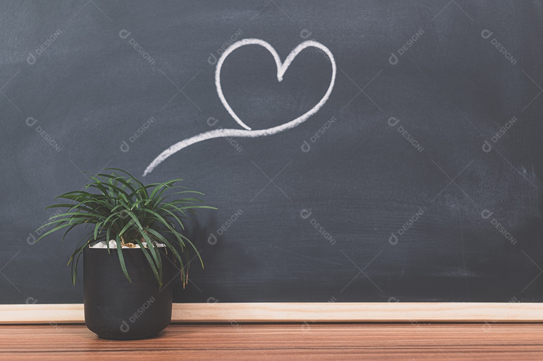 Vaso de plantas e formas de coração no quadro-negro