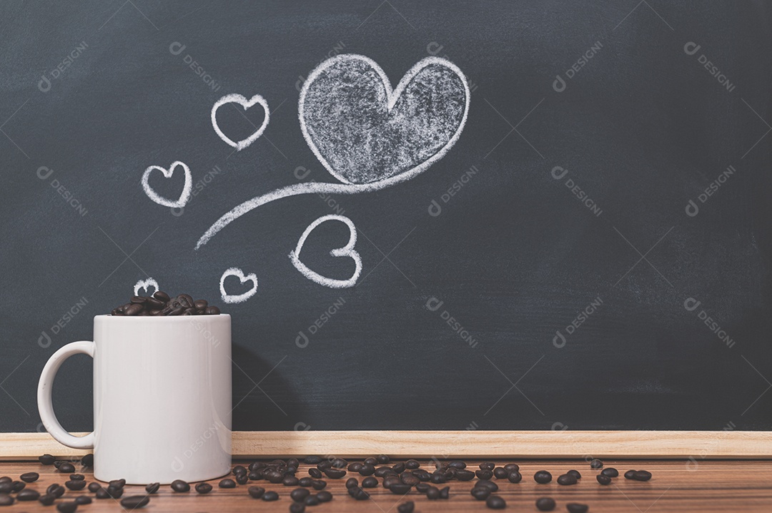 Canecas de café e grãos de café, o símbolo de forma de coração no quadro-negro.