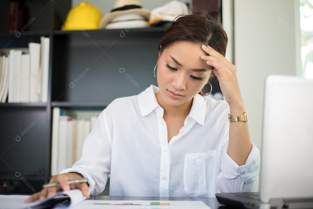 Empresária asiática séria sobre o trabalho feito até a dor de cabeça