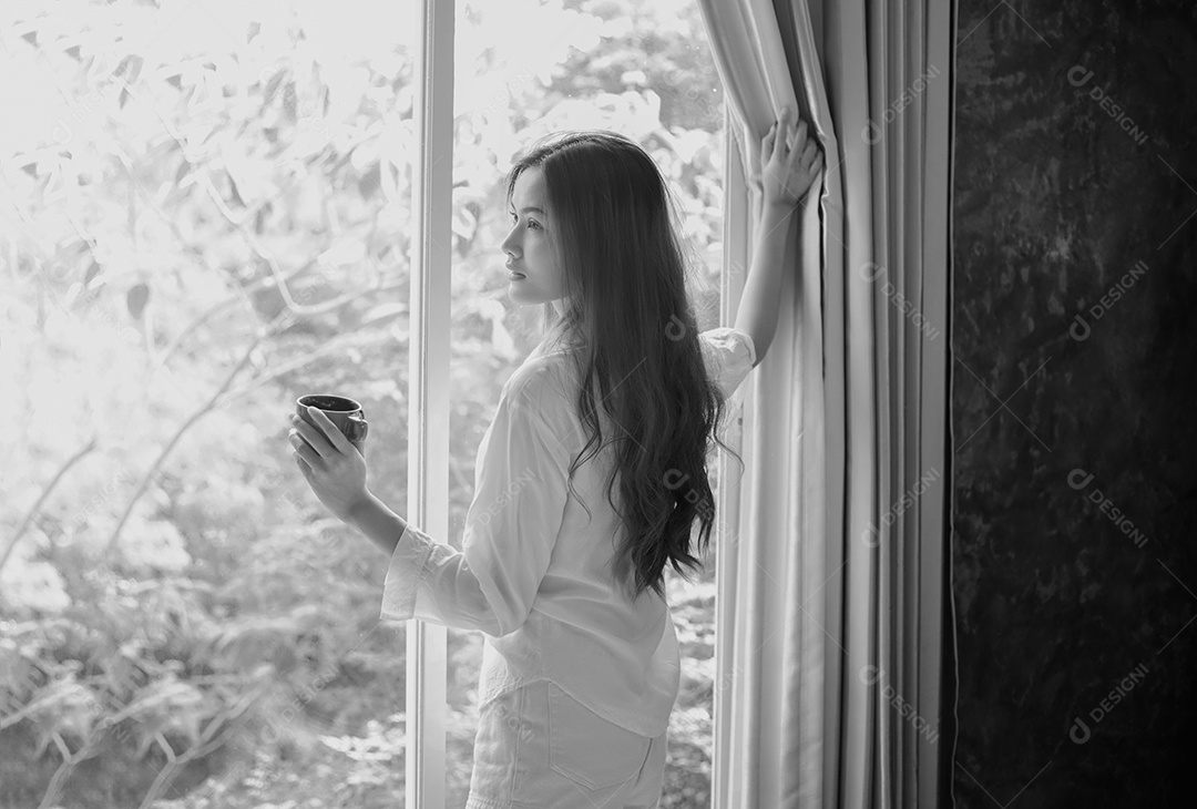 Mulher asiática tomando café no sol da manhã