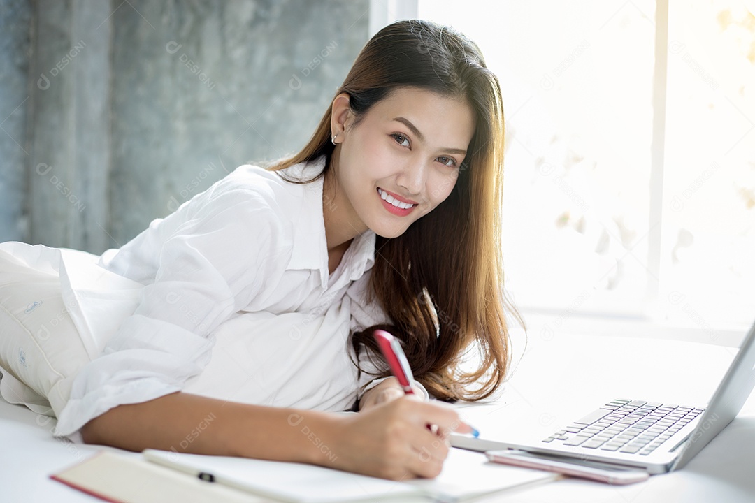 Mulher de negócios asiáticos usando notebook e sorrindo felizes por trabalhar e escrever