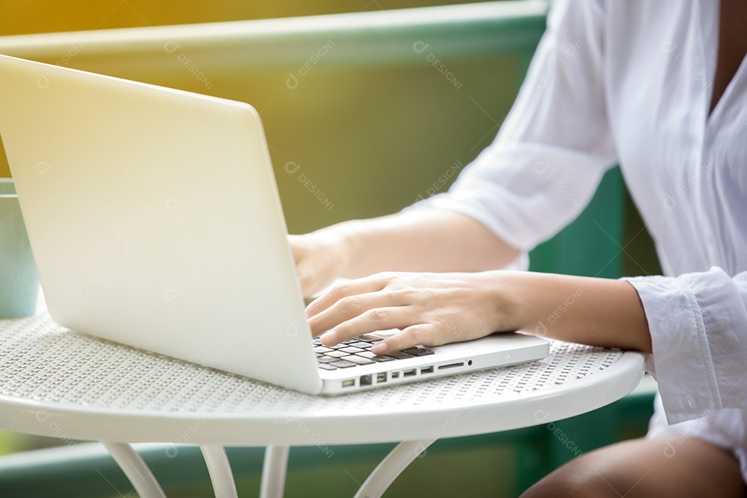 Mulher de negócios asiático usando notebook e sorrindo felizes por trabalhar ao ar livre