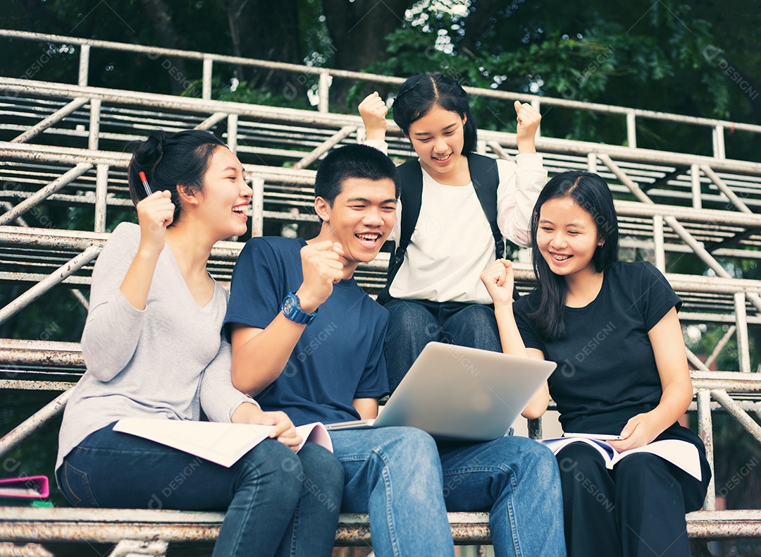 Grupo asiático de estudantes compartilhando ideias para trabalhar no gramado do campus