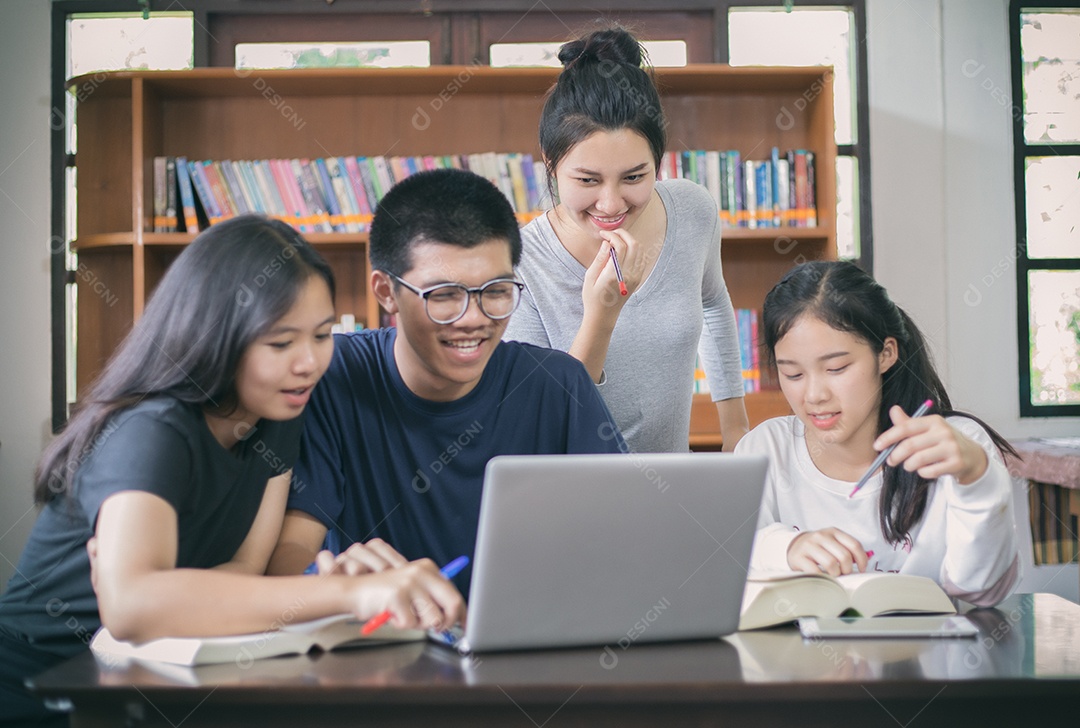 Grupo asiático de estudantes compartilhando ideias para trabalhar no gramado do campus