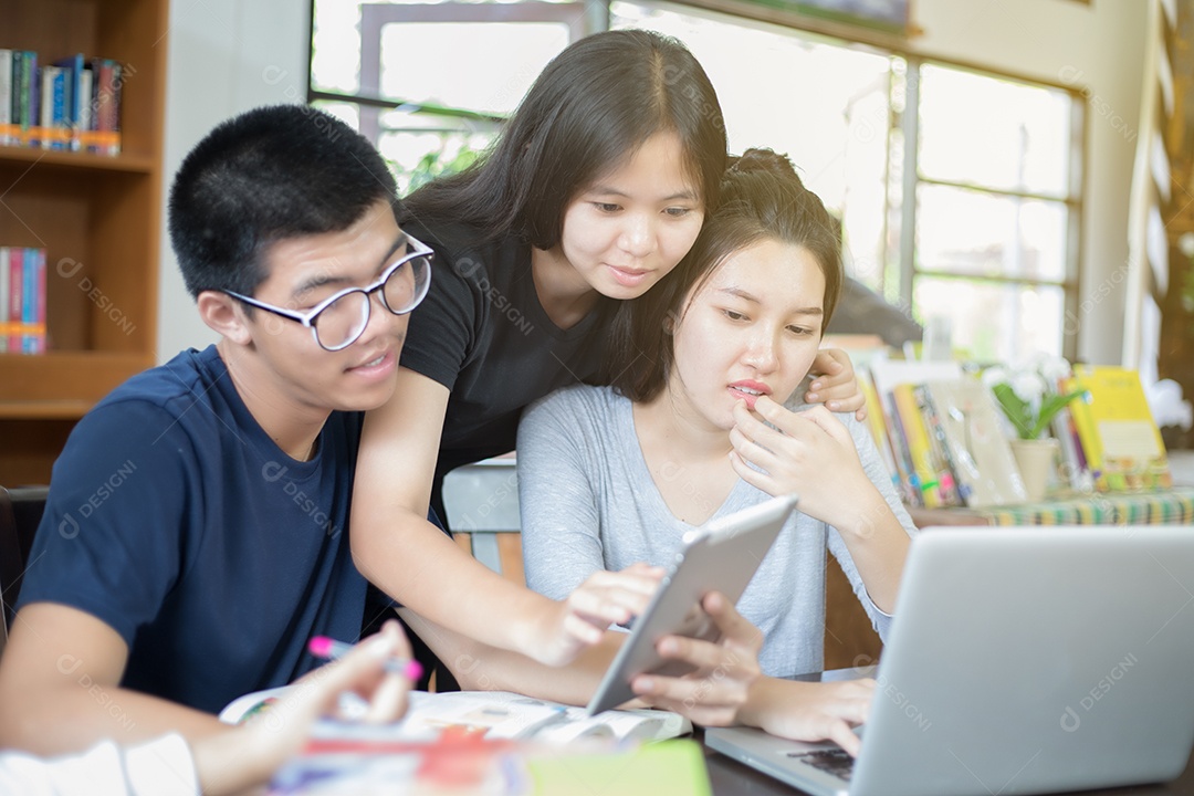 Grupo asiático de estudantes compartilhando ideias para trabalhar no gramado do campus