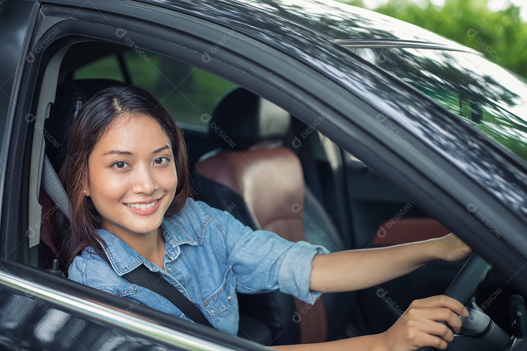 Mulher asiáticas estão ajustando o espelho retrovisor do carro