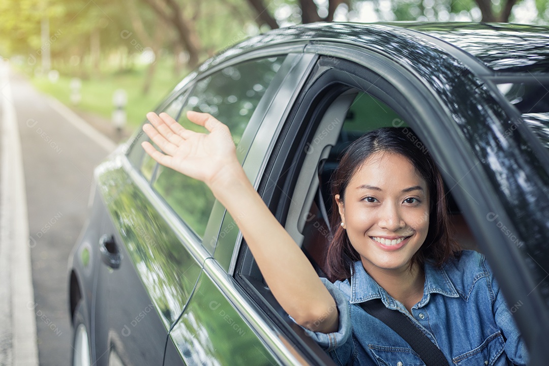 Linda mulher asiática sorrindo e se divertindo dirigindo um carro na estrada para viajar