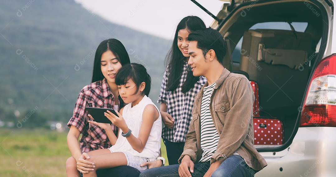 Menina feliz e com família asiática sentada no carro para curtir a viagem e as férias de verão na van campista