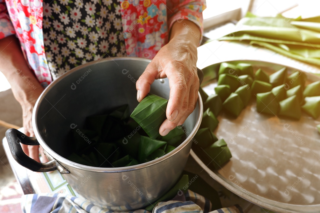 Fazendo doces folclóricos tailandeses embrulhados em folhas de bananeira devido ao festival de ano novo tailandês