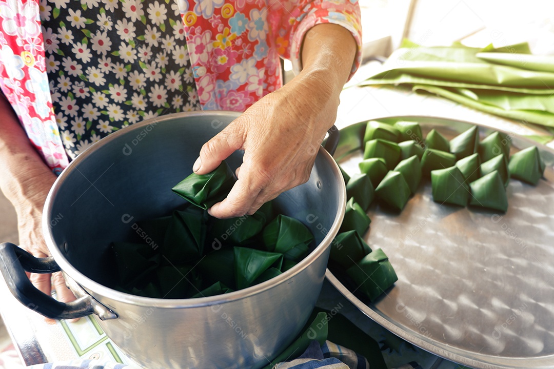 Fazendo doces folclóricos tailandeses embrulhados em folhas de bananeira devido ao festival de ano novo tailandês