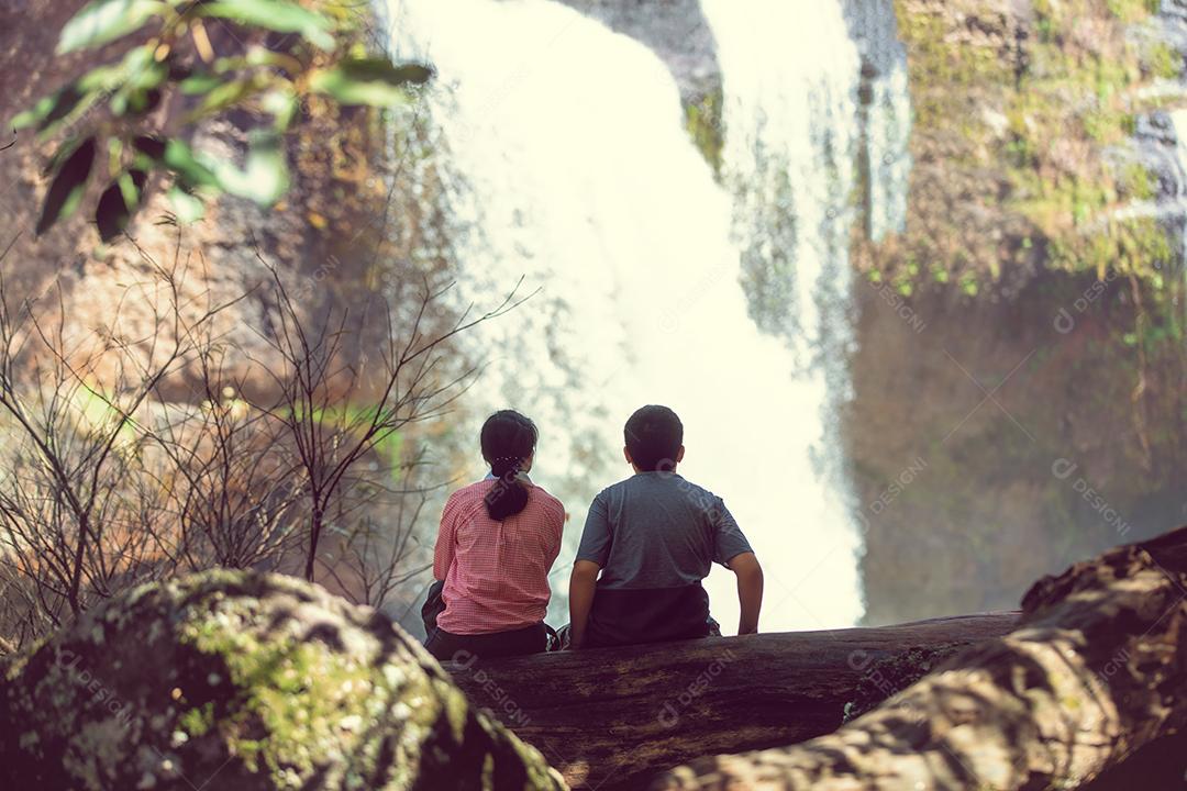 casal sentados juntos na cachoeira com felicidade e romance.