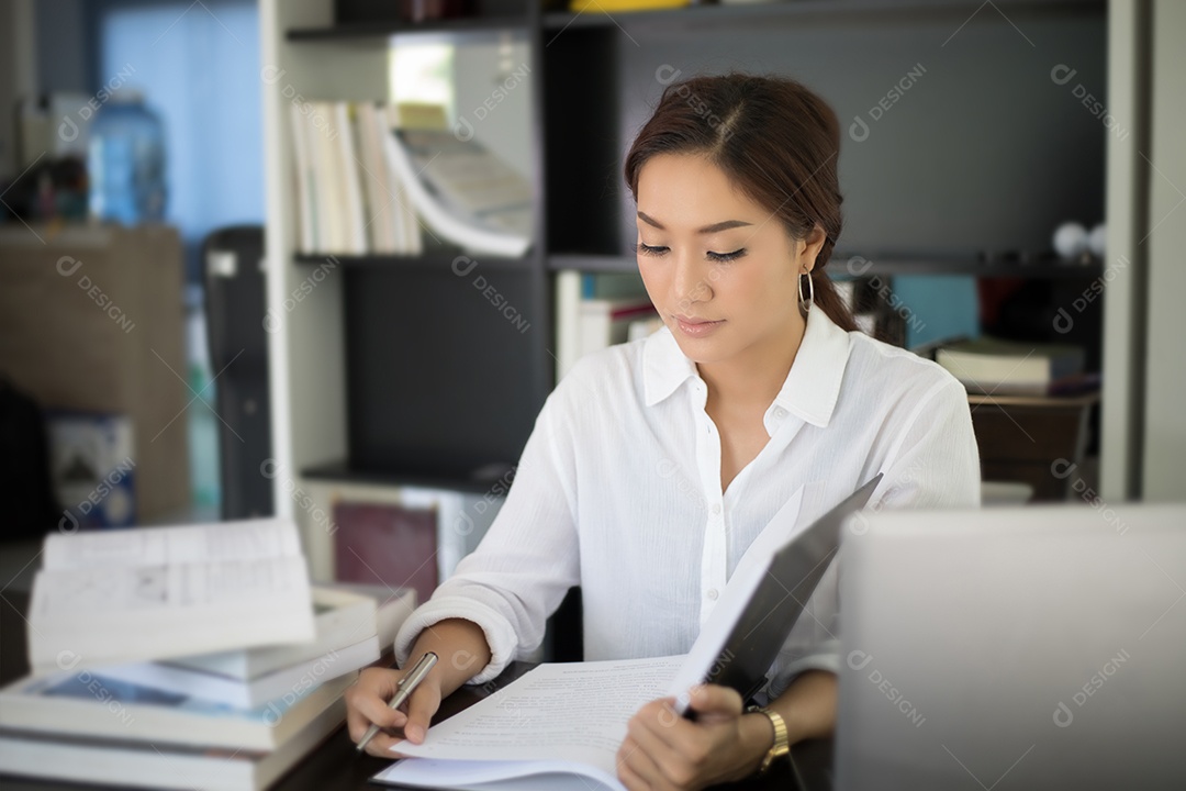 Estudante asiática sorrindo e sinal de mão Thump up e lendo um livro para relaxamento e exame final