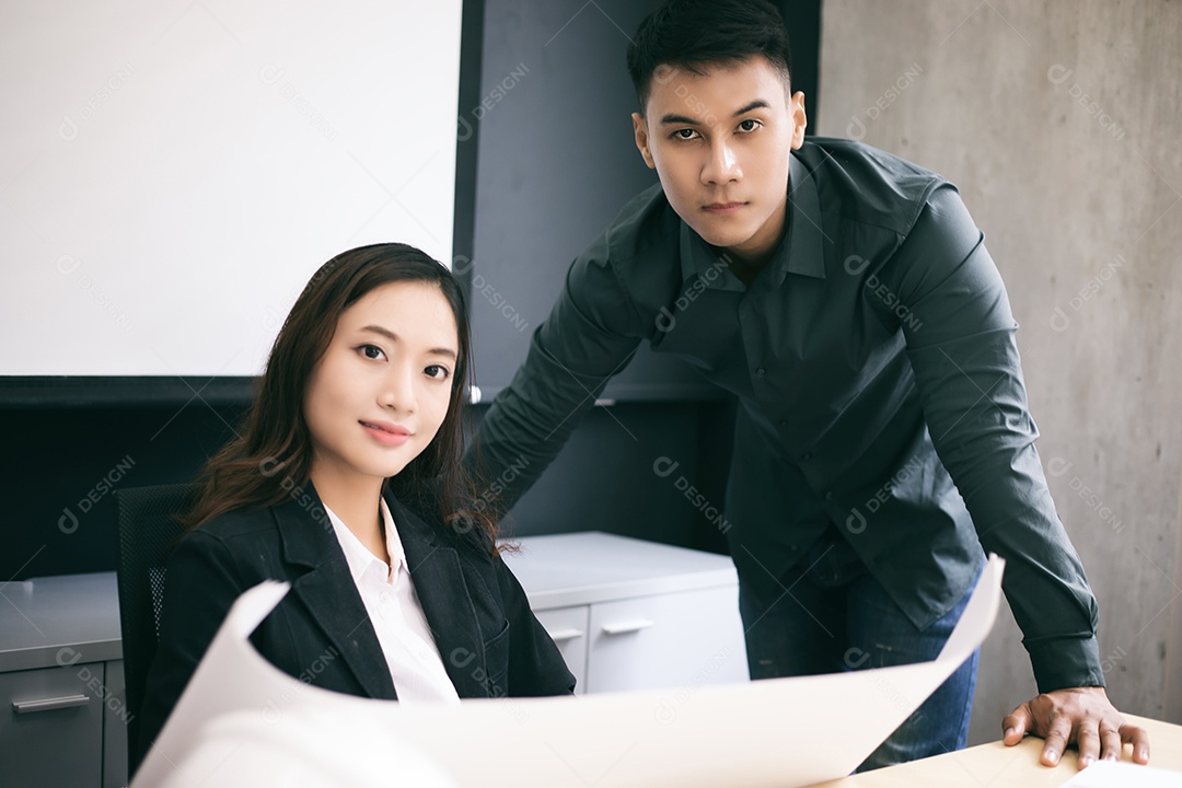 Mulher e engenheiros asiáticos discutindo projetos de negócios e sorrindo no escritório, foco suave e embaçado