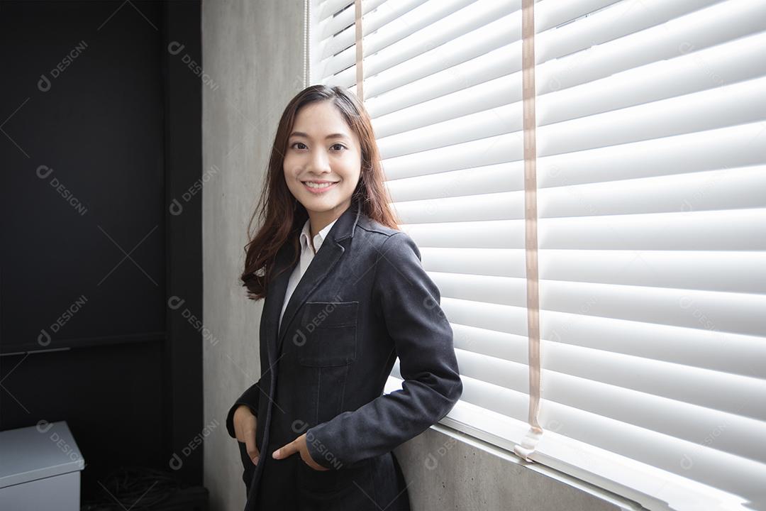 Mulher de negócios asiática sorrindo e feliz por trabalhar no escritório