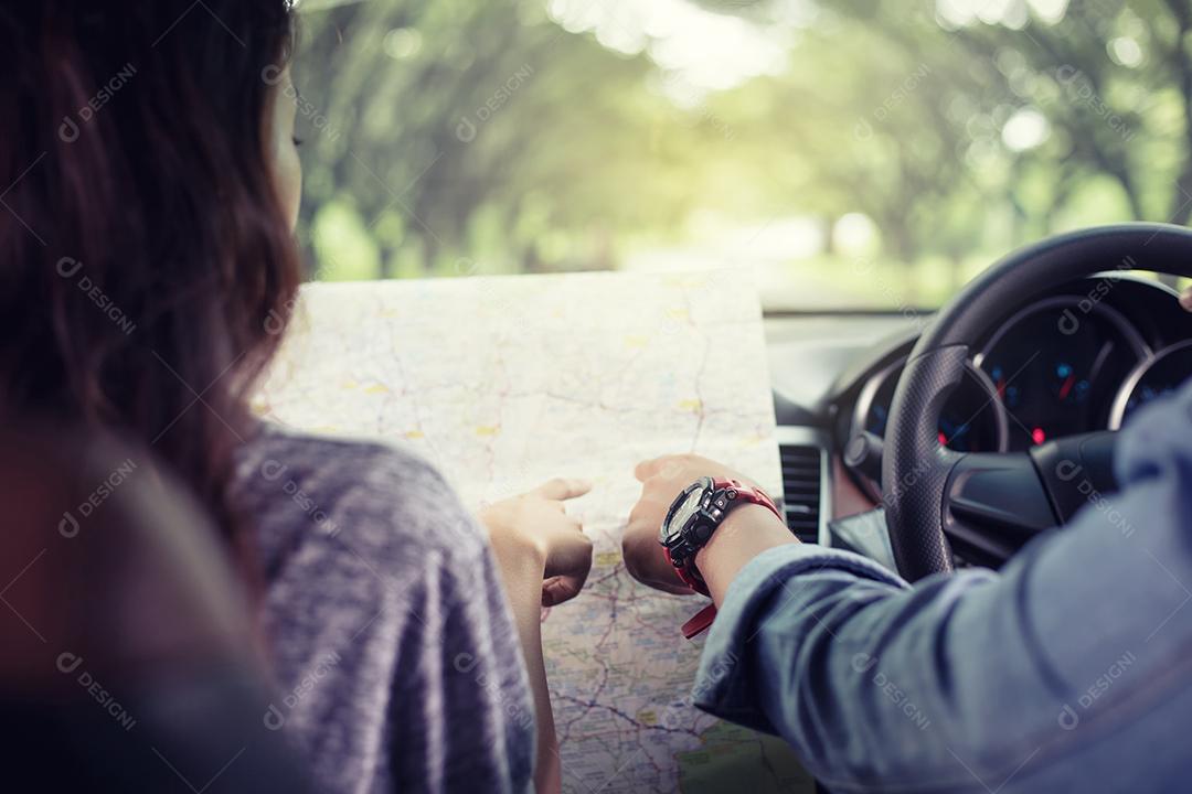 Homem e mulher asiáticos usando mapa na viagem e casal jovem feliz com um mapa no carro