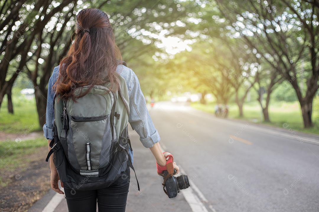 Fotógrafo de mulher segurando uma câmera em estado selvagem para tirar uma foto do viajante turístico