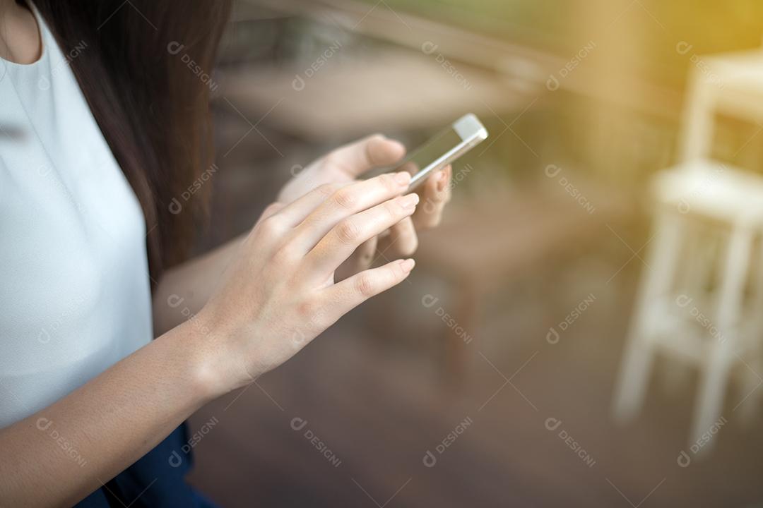 mulher asiática usando telefone para celular e mensagens de texto em seu celular