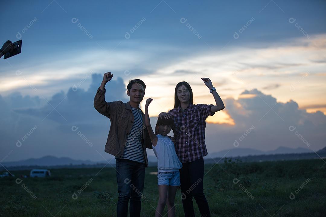 Família feliz se divertindo e curtindo a viagem no parque na hora do pôr do sol