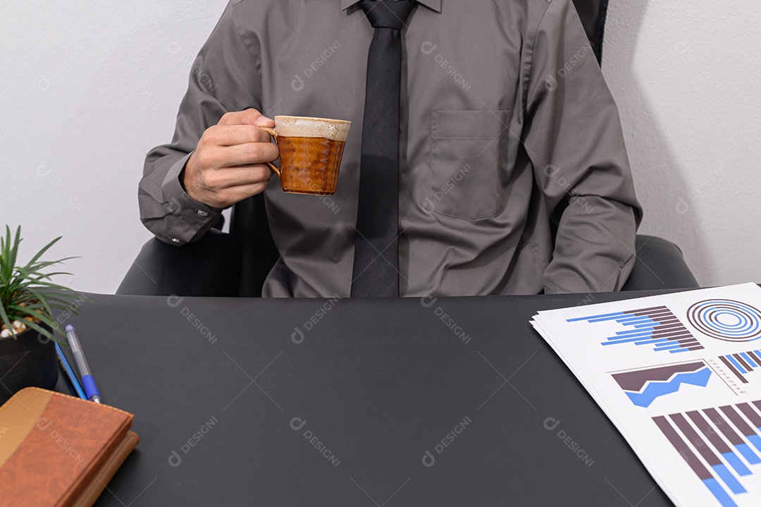 Homem de negócios tomando café em sua mesa