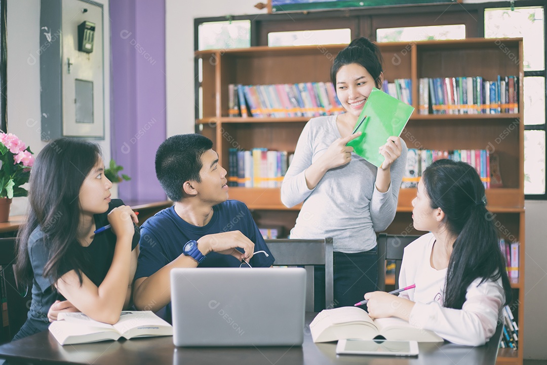 Grupo asiático de estudantes compartilhando ideias para trabalhar no gramado do campus