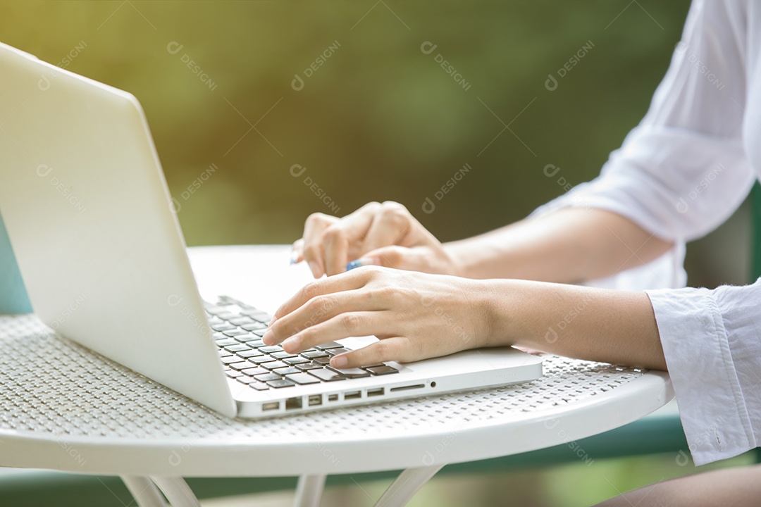 Mulher de negócios asiáticos usando notebook e sorrindo felizes por trabalhar