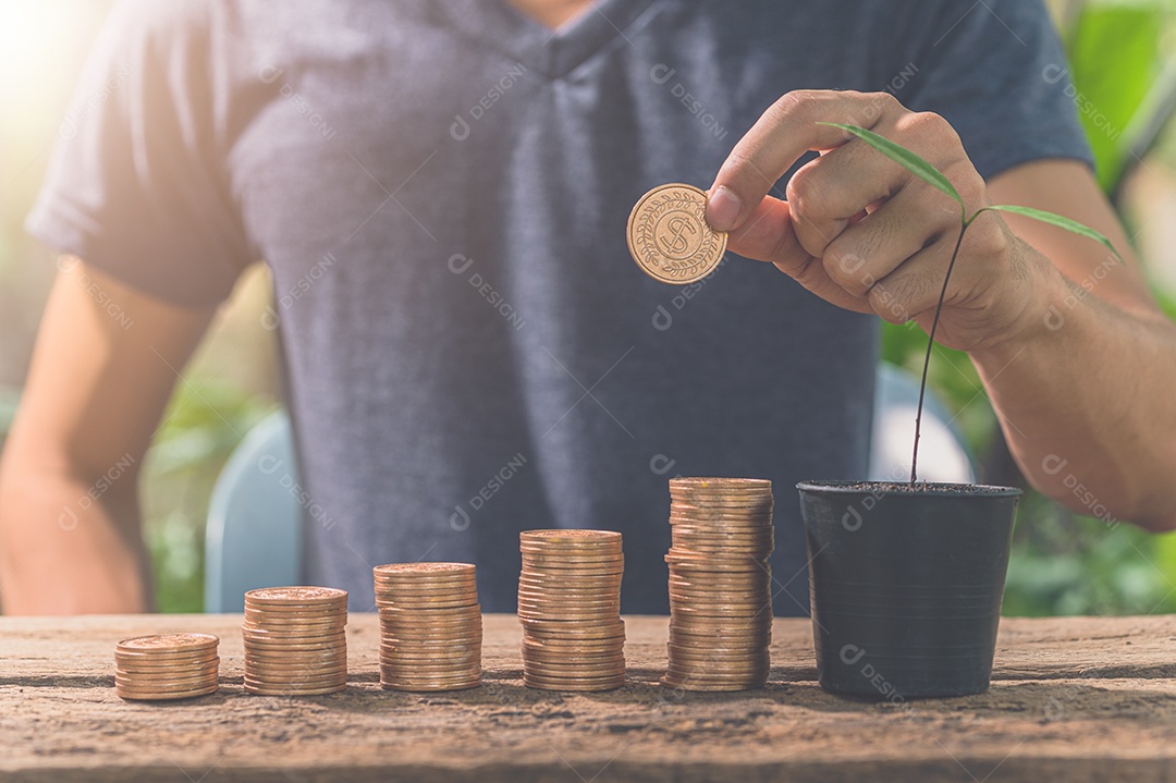 Homem reunindo moedas. O conceito de crescimento financeiro.