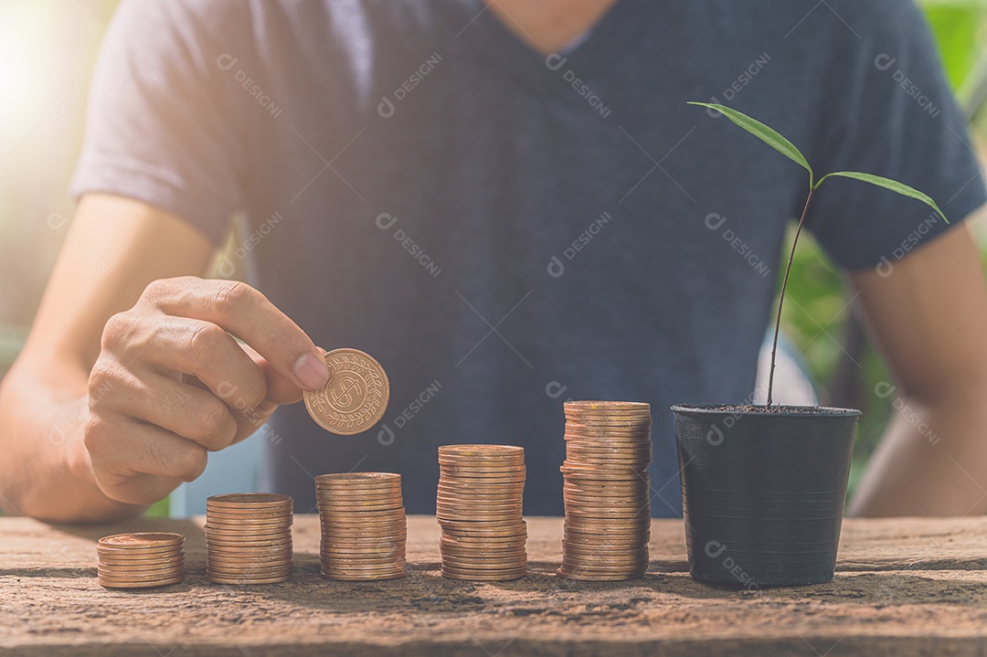 Homem reunindo moedas. O conceito de crescimento financeiro.