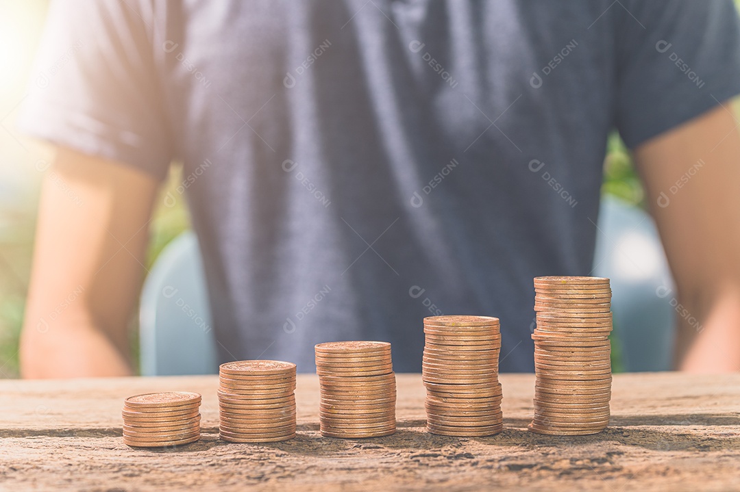 Homem reunindo moedas. O conceito de crescimento financeiro.