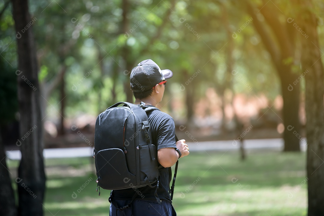 homem asiático com mochila brilhante do viajante turístico na natureza
